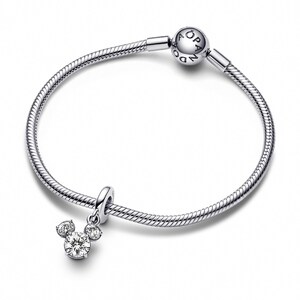 A silver-toned bracelet with a charm featuring a Mickey Mouse design and a small crystal pendant.