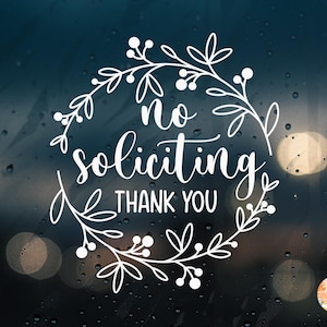 Könnte beinhalten: Weißes Vinyl-Abziehbild mit den Worten "no soliciting thank you" in einer dekorativen Schriftart, umgeben von einem floralen Kranz. Das Abziehbild ist für die Anbringung an einem Fenster oder einer Tür bestimmt.