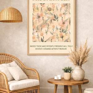Op de afbeelding: Een ingelijste print met de tekst "SURAH ZUMAR:10" en een bloemenpatroon in beige, perzik en groen. De tekst "INDEED THOSE WHO PATIENTLY PRESERVE WILL TRULY RECIEVE A REWARD WITHOUT MEASURE" staat eronder. De print wordt weergegeven in een kamer met een rieten stoel en een houten tafel.