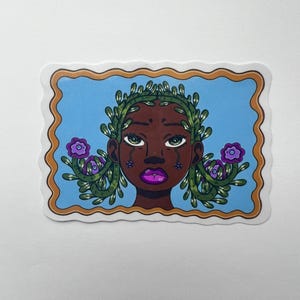 May include: A sticker featuring a stylized illustration of a person with dark skin, adorned with green foliage and purple flowers. The person has purple lips and tears, set against a blue background with a brown and gold border. The sticker has a wavy edge.