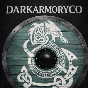 以下が含まれることがあります： 水色の木材の表面と白いバイキング風のデザインが施された丸い盾。盾の中央は黒く、縁は金属製です。「DARKARMORYCO」の文字が上部にあります。
