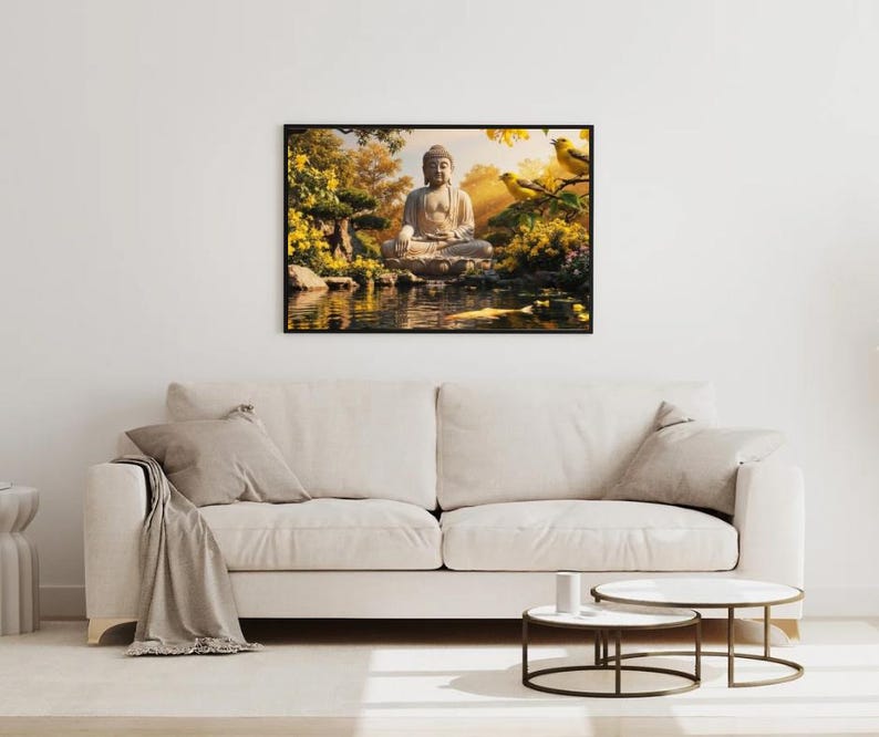 May include: A framed artwork depicting a serene scene with a seated Buddha statue near a pond. The artwork features a black frame, with yellow and green foliage, and two yellow birds. The artwork is hanging above a beige sofa.