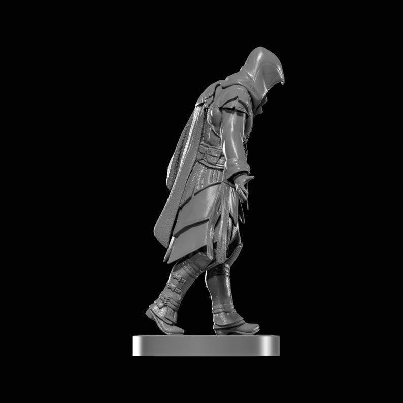 May include: A gray figurine of a hooded figure in a cloak, walking forward. The figure is wearing boots and a tunic with intricate details. The figurine is on a rectangular base, set against a black background.