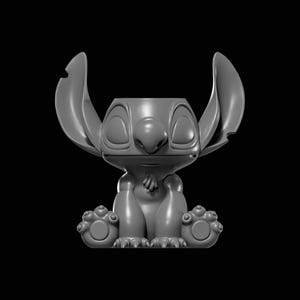 May include: A gray, 3D-printed figurine of the character Stitch from the animated film Lilo & Stitch. The figurine is in a seated position with large ears, a prominent nose, and large eyes. The figure is on a black background.
