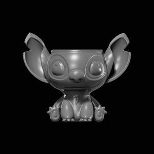 May include: A grey, 3D-printed figurine of a cartoon character with large ears, large eyes, and a small nose. The figurine has a small body with four stubby limbs. The character is in a sitting position. The background is black.
