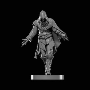 May include: A grayscale figurine of a character in a hooded cloak, with arms outstretched. The figure is wearing a tunic, cape, and boots. The figurine is standing on a rectangular base against a black background.