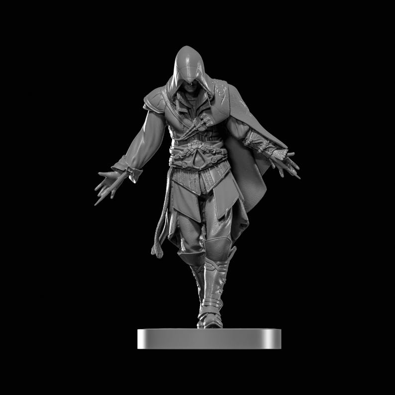May include: A grayscale figurine of a character in a hooded cloak, with arms outstretched. The figure is wearing a tunic, cape, and boots. The figurine is standing on a rectangular base against a black background.
