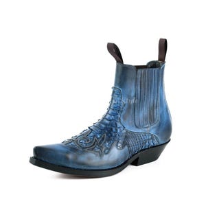 May include: Blue leather ankle boot with a pointed toe and decorative stitching. The boot features a textured pattern on the vamp and a pull tab at the back. The boot has a black sole and a low heel.