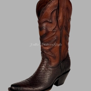 Könnte beinhalten: Ein brauner Leder-Cowboystiefel mit spitzer Zehenpartie und einem gestapelten Absatz. Der Stiefel hat ein strukturiertes, schlangenartiges Muster am unteren Teil und dekorative Nähte am oberen Schaft. Der Text "Jaliz Western Style" ist sichtbar.