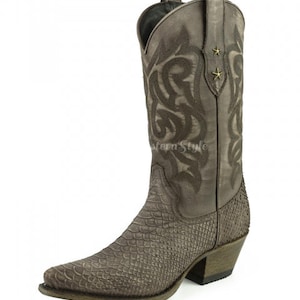 May include: A brown cowboy boot with a pointed toe and a textured, snake-like pattern on the lower part. The upper part features decorative stitching and two small gold-coloured star accents. The boot has a stacked heel.