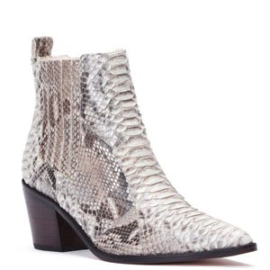 May include: A white and gray snakeskin-patterned ankle boot with a pointed toe and a stacked block heel. The boot features a side panel and a pull tab at the back. The heel is approximately 3 inches high.