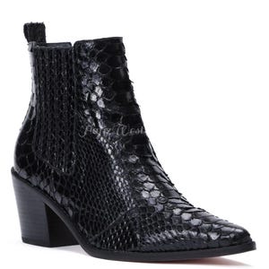 Könnte beinhalten: Schwarze Stiefeletten mit Schlangenmuster. Die Stiefel haben eine spitze Zehenpartie, einen Blockabsatz und elastische Seiteneinsätze. Die Absatzhöhe beträgt ca. 7,6 cm.