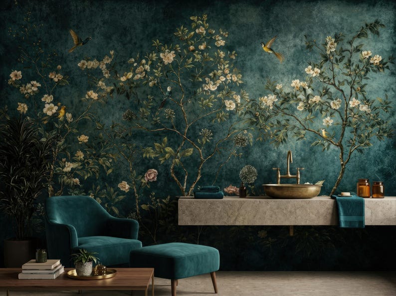 May include: A teal armchair and ottoman sit in front of a wall mural depicting a floral and bird design. The mural features a dark teal background with flowering branches and birds. A gold-toned sink and faucet are also visible.