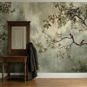 Puede incluir: Un espejo con marco de madera y una peque&ntilde;a mesa se alzan contra una pared con un mural de una escena de bosque. Un abrigo oscuro cuelga del marco del espejo. Dos p&aacute;jaros se posan en una rama de &aacute;rbol en el mural. La habitaci&oacute;n tiene suelo de madera.
