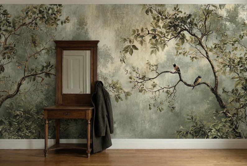 Puede incluir: Un espejo con marco de madera y una peque&ntilde;a mesa se alzan contra una pared con un mural de una escena de bosque. Un abrigo oscuro cuelga del marco del espejo. Dos p&aacute;jaros se posan en una rama de &aacute;rbol en el mural. La habitaci&oacute;n tiene suelo de madera.
