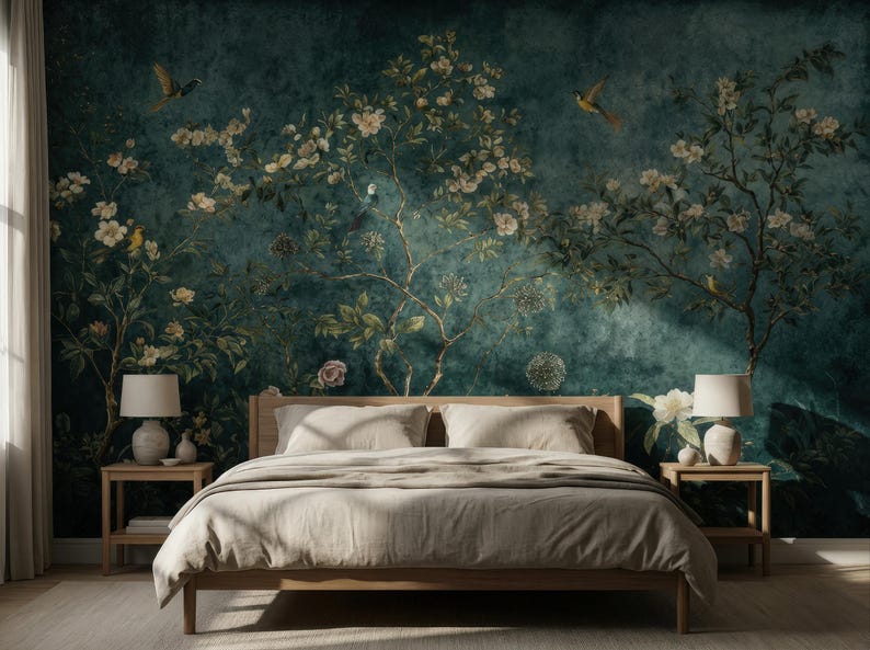 May include: A bedroom with a wooden bed frame and a beige comforter. The headboard is against a teal wall mural depicting flowering branches and birds. Two matching nightstands with lamps flank the bed. The room is illuminated by natural light.