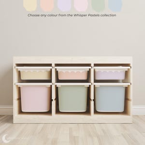 May include: A wooden storage unit with six pastel-coloured bins. The bins are in shades of yellow, peach, lavender, green, pink, and blue. The text above reads, "Choose any colour from the Whisper Pastels collection."