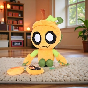 May include: A plush toy in the shape of a pumpkin with large black eyes, a smiling mouth, and green and orange accents. The toy has two orange slices and a small green leaf. The toy is sitting on a beige rug.