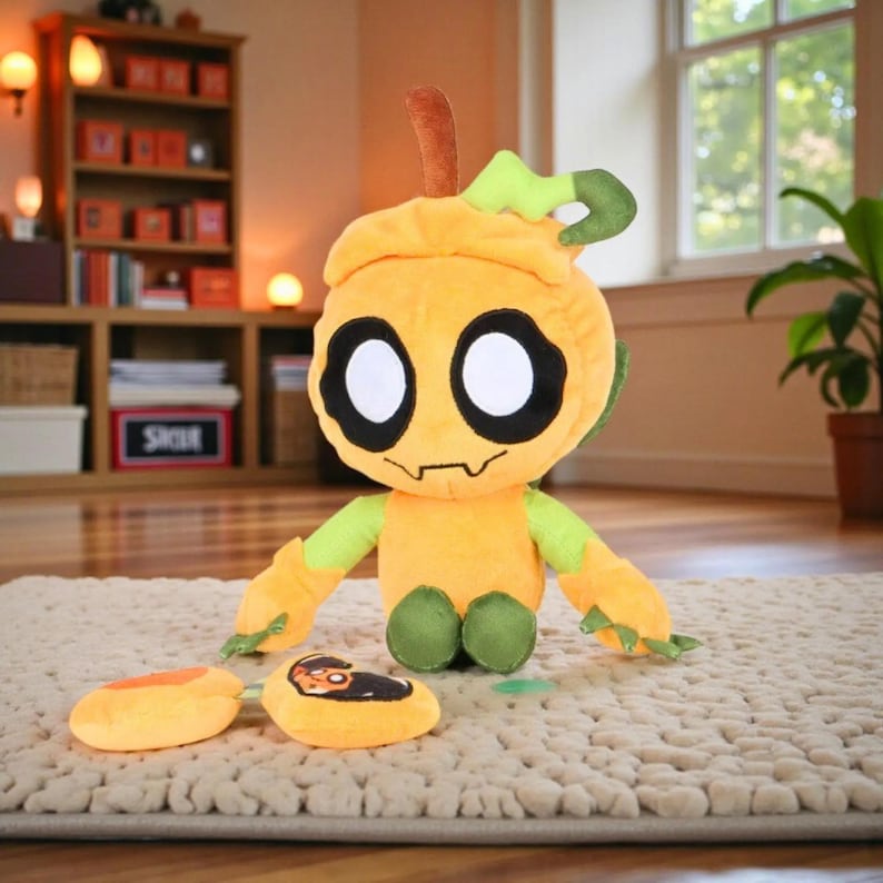 May include: A plush toy in the shape of a pumpkin with large black eyes, a smiling mouth, and green and orange accents. The toy has two orange slices and a small green leaf. The toy is sitting on a beige rug.