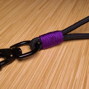 May include: A set of three ceramic mugs with a speckled, cream-colored glaze. Each mug features a different hand-painted design: a blue and green leaf, a yellow flower, and a red berry. The mugs have a simple, modern design.