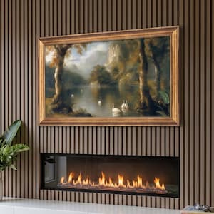 May include: A linear fireplace integrated into a wall with vertical brown wood slats, featuring a landscape painting in a gold frame above the flames. A white floating cabinet sits below the fireplace, holding a green plant and books.