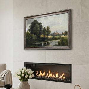 Könnte beinhalten: Wohnzimmer mit Landschaftsbild über einem Kamin. Ein beiger Sessel, ein runder Holztisch mit einer Vase mit weißen Tulpen und ein Weidenkorb sind ebenfalls zu sehen.
