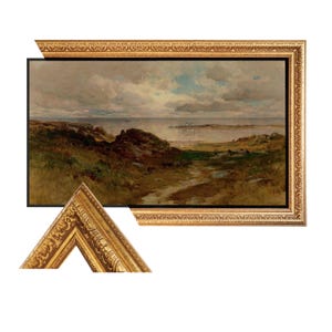 May include: A framed landscape painting depicting a coastal scene with a cloudy sky. The artwork features a path leading to the water, with rocks and vegetation in the foreground. The frame is ornate, gold-colored, and rectangular.