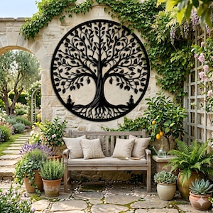 Op de afbeelding: Een cirkelvormig zwart metalen wandkunstwerk met een gedetailleerd levensboomontwerp met complexe takken, bladeren en wortels, inclusief twee kleine silhouetten van figuren in een zittende meditatiehouding aan de voet van de boomstam.