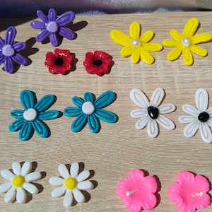 May include: A set of three ceramic mugs with a speckled, matte finish. Each mug features a different color: light blue, cream, and gray. The mugs have a simple, modern design and a comfortable handle.