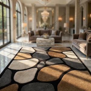 May include: A rectangular area rug with a pebble design. The rug features large, irregularly shaped stones in shades of brown, gray, and cream, set against a black background. The rug is placed in a luxurious living room setting.