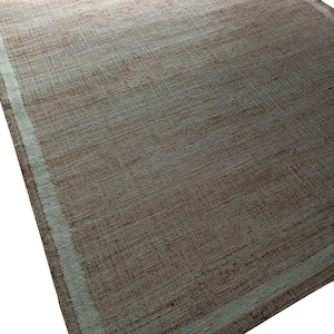 Peut inclure: Tapis rectangulaire tiss&eacute;, aux tons bruns et beiges. Il pr&eacute;sente une bordure beige clair qui encadre le corps principal. La texture semble rugueuse, avec des fils tiss&eacute;s visibles. Id&eacute;al pour un salon.