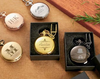 Op de afbeelding: Collectie gegraveerde zakhorloges in goud, zilver en roségoud. Sommige worden in zwarte dozen gepresenteerd. De wijzerplaten tonen gepersonaliseerde teksten en ontwerpen. Afmetingen niet beschikbaar.