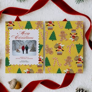 May include: A Christmas card with a yellow background featuring a family photo and festive illustrations. The card includes the text "Merry Christmas" and a pattern of gingerbread men, Santa, candy canes, and Christmas trees. Red ribbon and pinecones surround the card.
