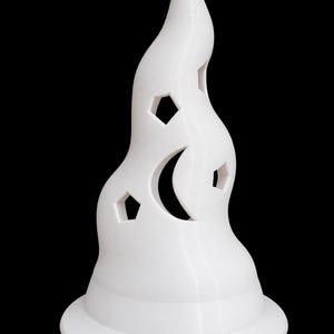 May include: A white, conical, flame-shaped object with a wide circular base. The surface features cutouts in the shapes of a crescent moon and several pentagons. The structure has a smooth, layered texture consistent with 3D printing techniques.