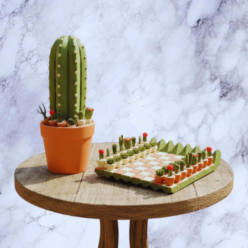 Puede incluir: Un juego de ajedrez decorativo con tem&aacute;tica de cactus. El conjunto incluye un gran cactus verde en una maceta naranja y un tablero de ajedrez con piezas de cactus. El tablero es verde y naranja.