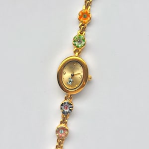 May include: A white ceramic mug with a black handle and the text "But First, Coffee" in a handwritten style. The mug is on a white surface. The mug is 10 cm tall.