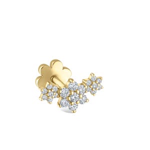 May include: A gold-colored earring featuring a floral design. The earring has a clover-shaped backing and three clusters of small, round, clear gemstones. The gemstones are set in a flower pattern.