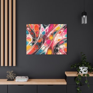 Peut inclure: Impression sur toile d'art abstrait avec un design vibrant et coloré. L'œuvre présente un motif fluide avec un mélange de couleurs vives, notamment du rose, de l'orange, du jaune, du bleu et du noir. La toile est tendue et prête à être accrochée.