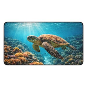 May include: A rectangular mouse mat depicting an underwater scene. A sea turtle swims above a colorful coral reef, with sunlight filtering through the water. The turtle has a brown and green shell and patterned flippers.