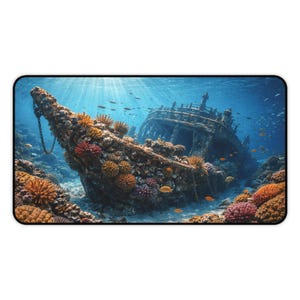 May include: A rectangular mousepad featuring an underwater scene of a sunken ship. The ship is covered in coral and surrounded by fish. The water is a clear blue, and sunlight streams down from above.