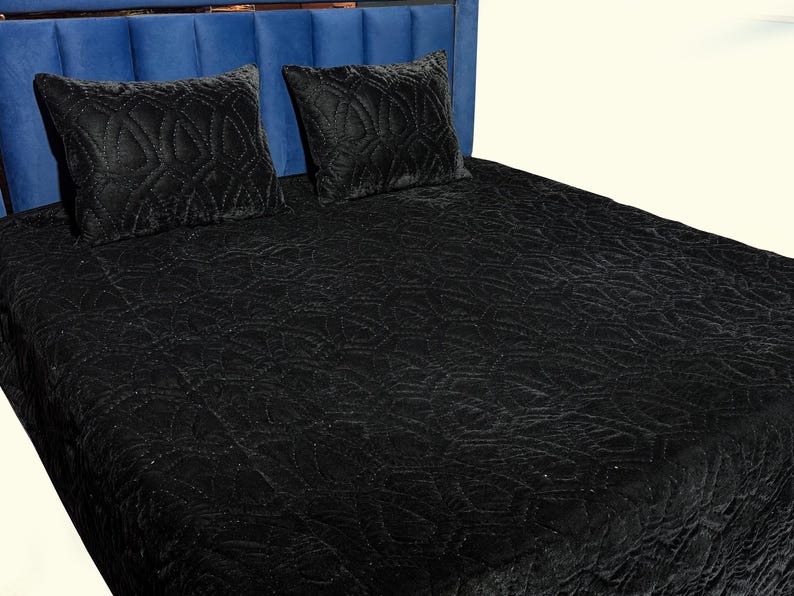 Black velvet hand stitched quilt with matching pillow covers on bed, luxury handmade bedding set with soft textured velvet fabric