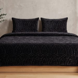 Black velvet hand stitched quilt with matching pillow covers on bed, luxury handmade bedding set with soft textured velvet fabric