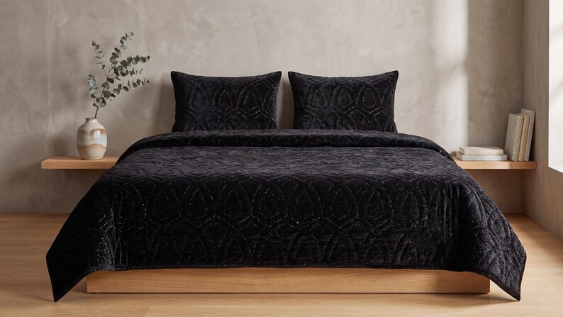 Black velvet hand stitched quilt with matching pillow covers on bed, luxury handmade bedding set with soft textured velvet fabric