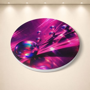 Puede incluir: Una obra de arte circular abstracta con tonos rosas y morados. Presenta varias esferas iridiscentes que reflejan múltiples colores, creando un efecto visual dinámico. La obra está montada sobre una base circular con borde blanco.