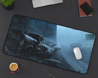 May include: A rectangular desk mat featuring a post-apocalyptic scene with a wrecked car on a road. The image is dark with a blue and gray color palette, and a mouse and laptop are visible.