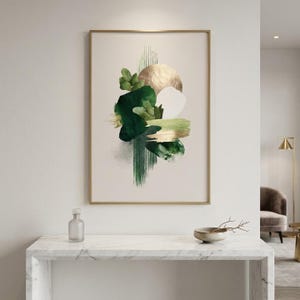 Peut inclure: Impression d'art abstrait dans un cadre doré. L'œuvre présente des coups de pinceau et des formes verts, blancs et dorés sur un fond neutre. Un cercle de couleur or est également présent. L'œuvre est exposée sur un mur blanc.