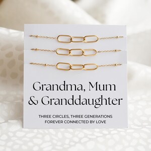 May include: Three gold-colored chain bracelets with a linked circle design are displayed on a white card. The card reads "Grandma, Mum & Granddaughter" with the text "THREE CIRCLES, THREE GENERATIONS FOREVER CONNECTED BY LOVE."