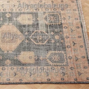 May include: A rectangular area rug with a dark blue central field and beige geometric patterns. The rug has a beige border with a fringe on one side. The text "Aliyaglobalrugs" is visible in the image.