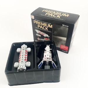 Peut inclure: Un coffret noir intitulé "SF Movie Selection Premium Pack" contient deux modèles de vaisseaux spatiaux pré-peints. L'un est un vaisseau spatial long, blanc et rouge, et l'autre est blanc avec des panneaux bleus. La boîte contient du texte japonais.
