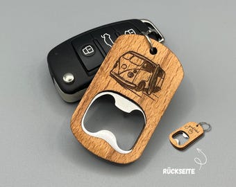 Könnte beinhalten: Flaschenöffner aus Holz mit silbernem Metallöffner und Schlüsselring. Der Öffner zeigt ein eingraviertes Bild eines Oldtimer-Vans und eines Surfbretts. Ein Autoschlüssel liegt daneben.